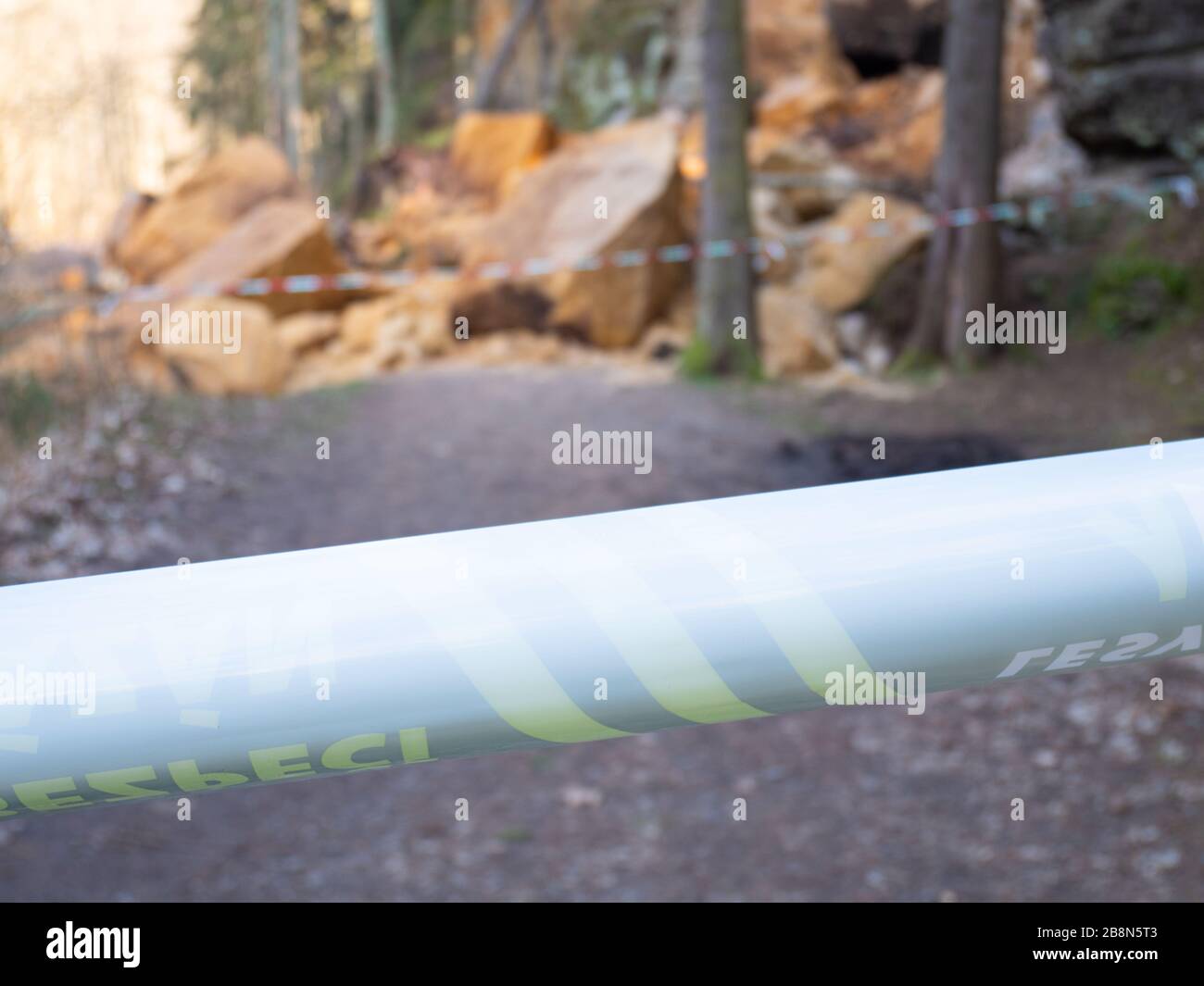 Keine Eingangszone. Zerbrochene Felsmassive von Hügel. Auf der Waldstraße stürzte Sandsteinmassiv ab. Geschlossener Bereich mit Polizeiband markiert. Stockfoto