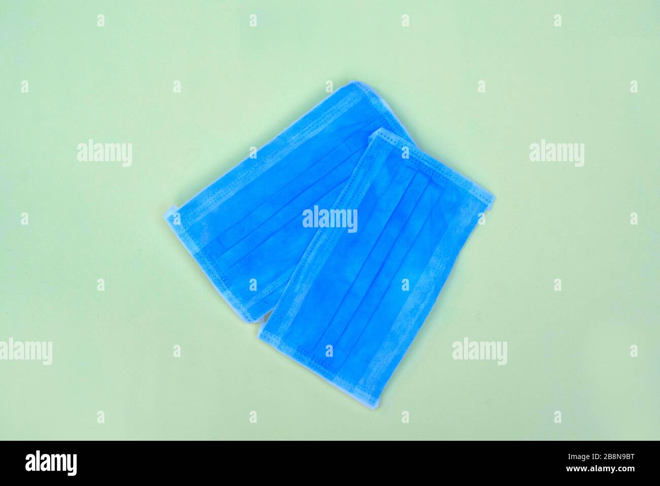 Zwei blaue Operationsmaske mit Gummibändern, isoliert auf hellblauem Hintergrund Stockfoto