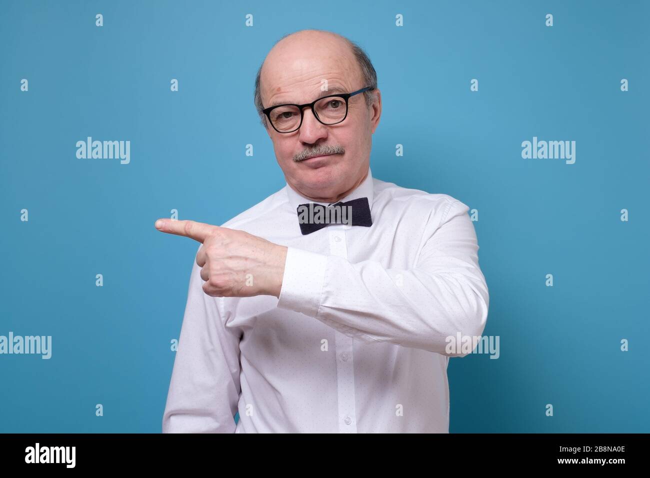 Selbstbewusster älterer Herr weisen weg. Ernst reifen männlichen Gestik mit Finger beiseite Stockfoto