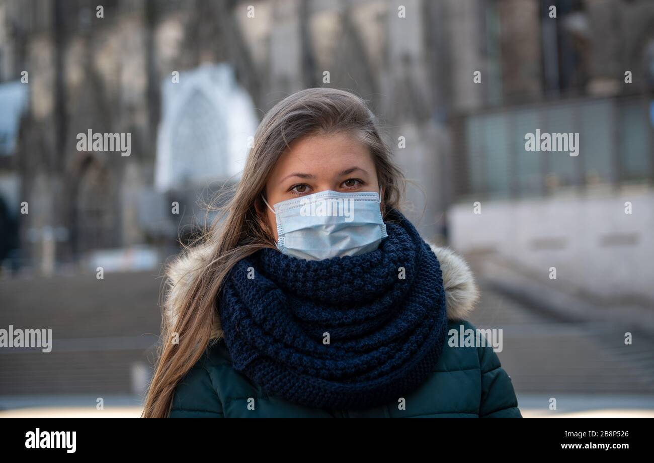 Porträt der jungen deutschen Frau vor dem Kölner Dom (Kölner Dom), Deutschland, mit medizinischer Maske againg Coronavirus (COVID-19) wieder kämpfend Stockfoto