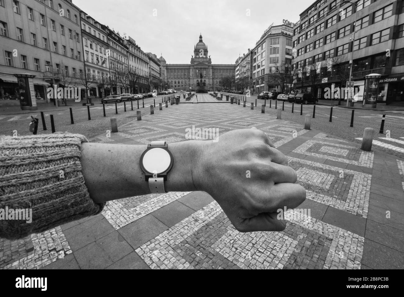 Fast desolater Wenzelsplatz (Václavské náměstí) in Prag, Tschechien, dargestellt um 13.27 Uhr während der Pandemie-Quarantäne des COVID-19-Coronavirus am 19. März 2020. Das Foto ist eine Hommage an das berühmte Foto des tschechoslowakische Fotografen Josef Koudelka, das während der sowjetischen Invasion in die Tschechoslowakei im August 1968 am selben Ort abgebildet wurde. Die handlose Uhr auf der linken Seite des Fotografen ist tatsächlich ein Eingangsspip zum Aquacentrum Šutka, der während der Quarantäne nutzlos ist, da alle Schwimmbäder aufgrund des Ausbruchs des Corona-Virus auch unbegrenzt geschlossen sind. Stockfoto