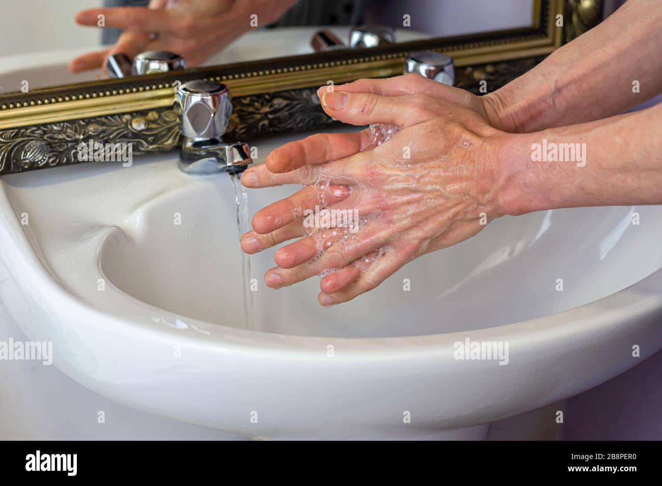 Person, die die Hände im Badezimmer waschen, um eine Infektion mit Coronavirus während der globalen Pandemie von Kovid-19 in UK.Social Issue.Healthy Lifestyle zu vermeiden. Stockfoto
