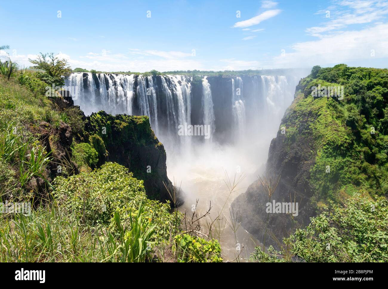 Weiter Blick auf den schönen Victoria Falls National Park von der Seite Simbabwes auf dem afrikanischen Kontinent. Wasserfälle in der Nähe der Grenze zu Sambia. Stockfoto