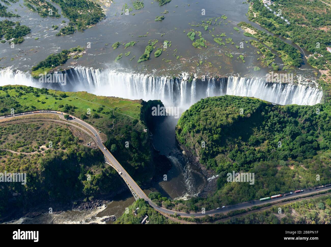 Luftaufnahme der Victoriafälle zwischen Simbabwe und Sambia in Afrika. Sieben Naturwunder der Welt. Fluss Sambezi und Grenzbrücke. Stockfoto