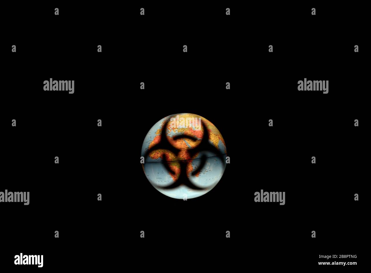 Verschwommenes biologischer Gefahrenschild (Schatten) auf dem Planeten Erde auf isoliertem schwarzem Hintergrund. Symbol für die biologische Gefahr (Coronavirus, COVID-19) - weltweite Bedrohung durch Pandemie. Stockfoto