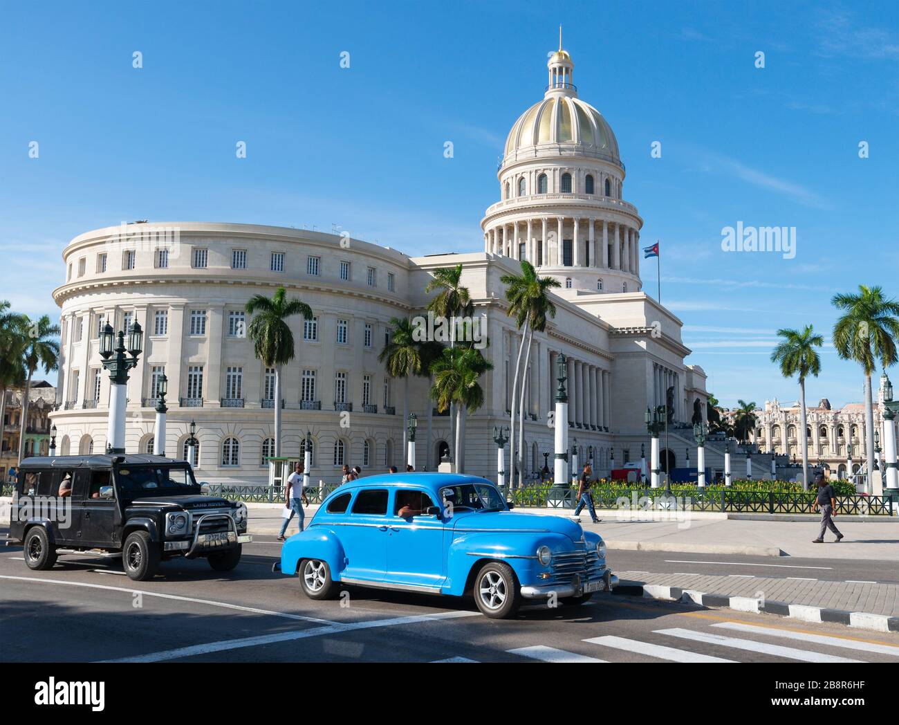 Oldtimer Plymouth und Land Rover vor dem kubanischen El Capitolio. Havanna, Kuba ist ein beliebtes Touristenziel in der Karibik. Stockfoto