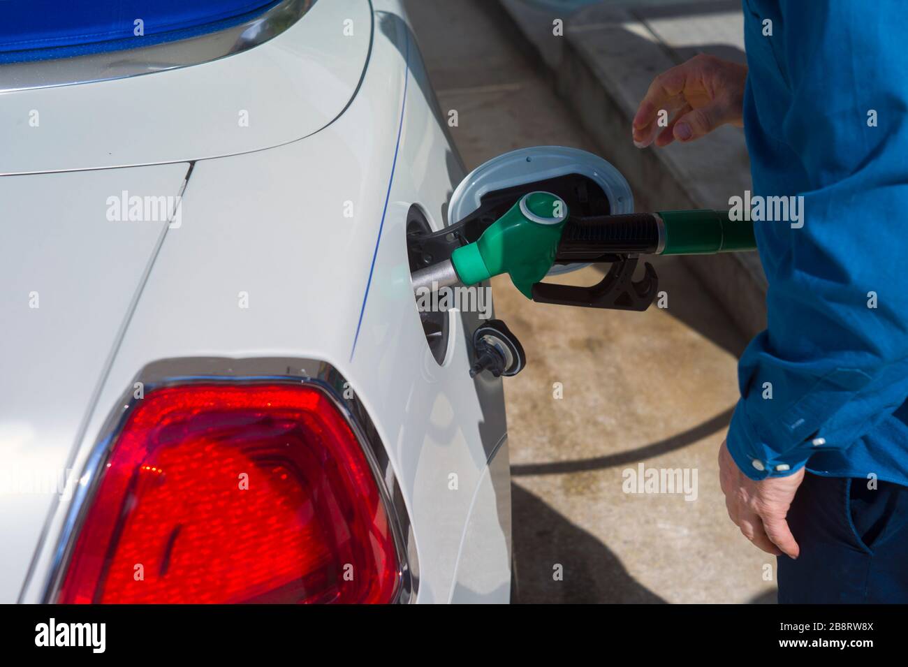 Ein Mann, der einen Tank mit Treibstoff füllt, sonniger Nahschuss am Tag Stockfoto