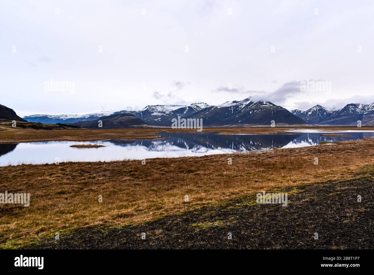 Schneebedeckte Berge über dem Wasser Stockfoto