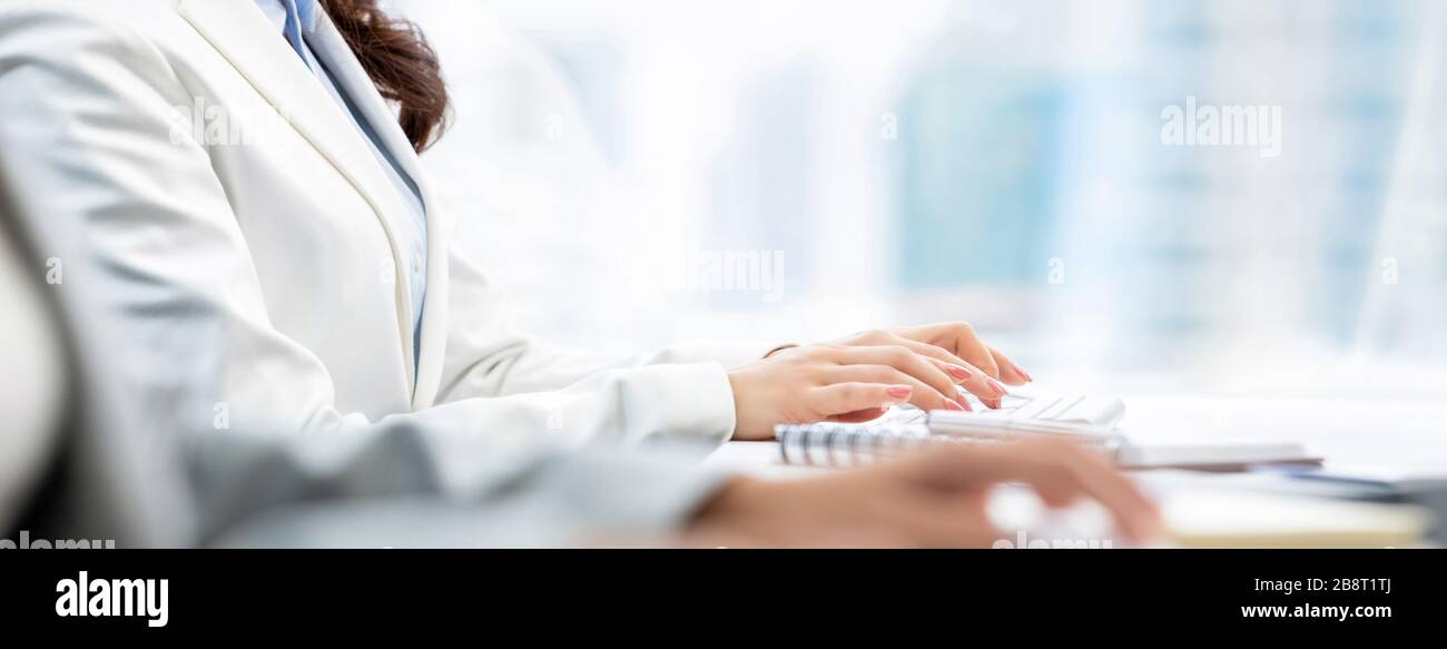 Hände von Frauen Angestellte mit weißem Kragen, die auf Computertastaturen tippen, die im Büro arbeiten, Bannergröße Stockfoto