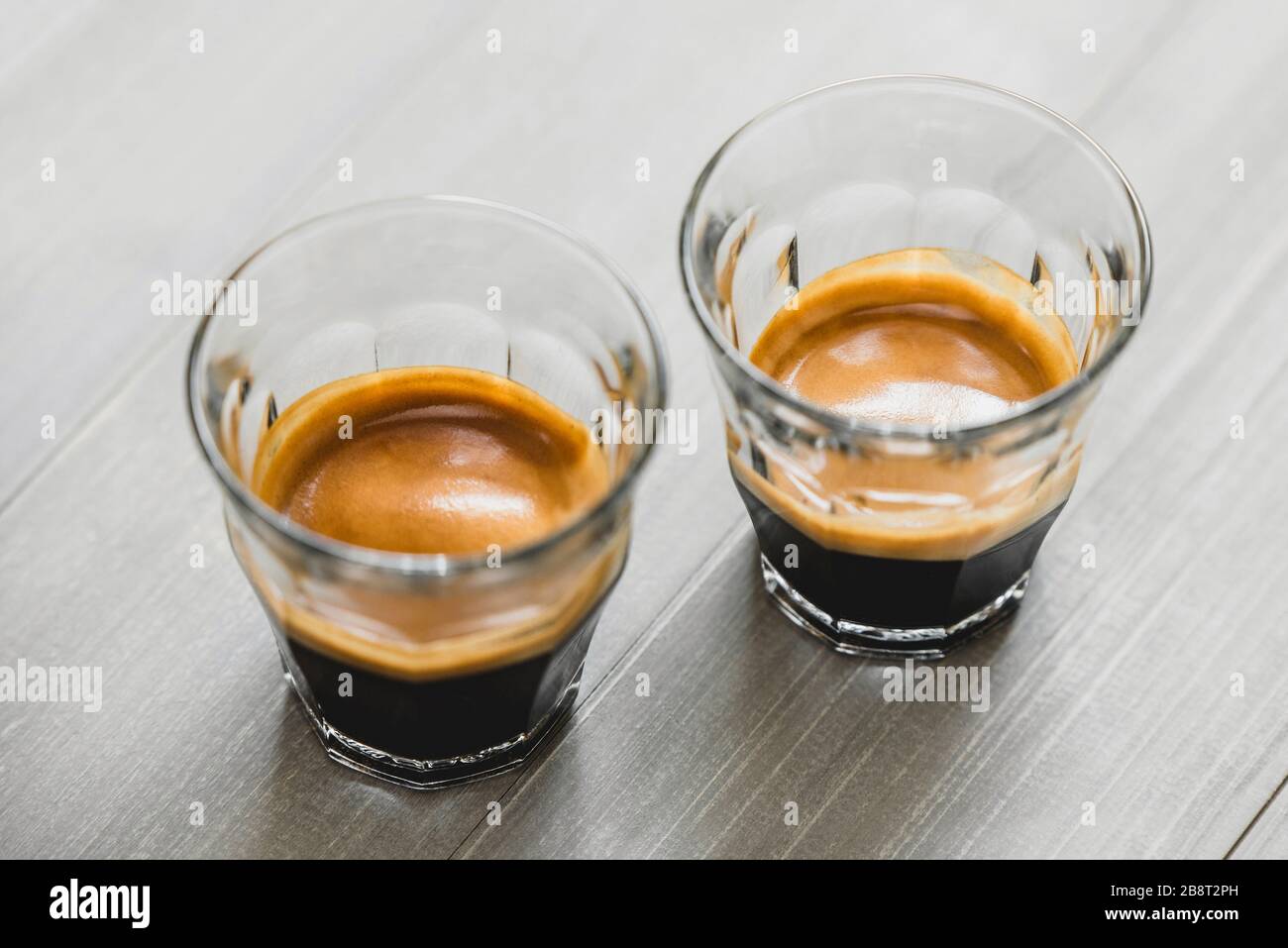 Doppeltes Espresso-Kaffee in der Brille auf Vintage-Holztisch-Hintergrund Stockfoto