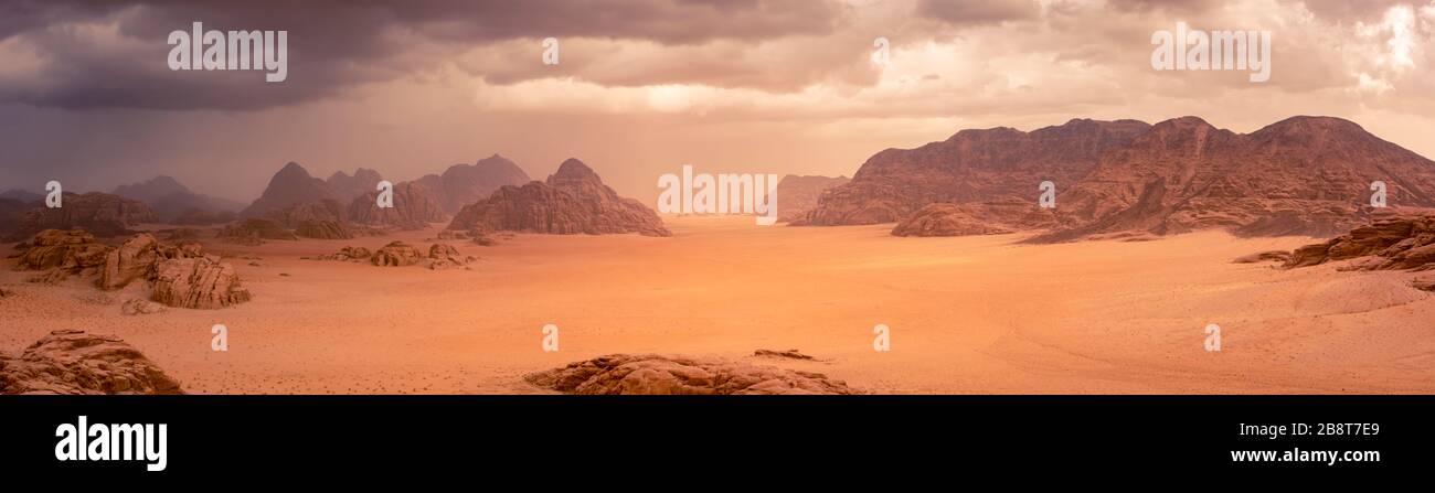 Wüste Wadi Rum in Jordanien unter drastischen Regenfällen und Sturmwolken. Panoramabild. Stockfoto
