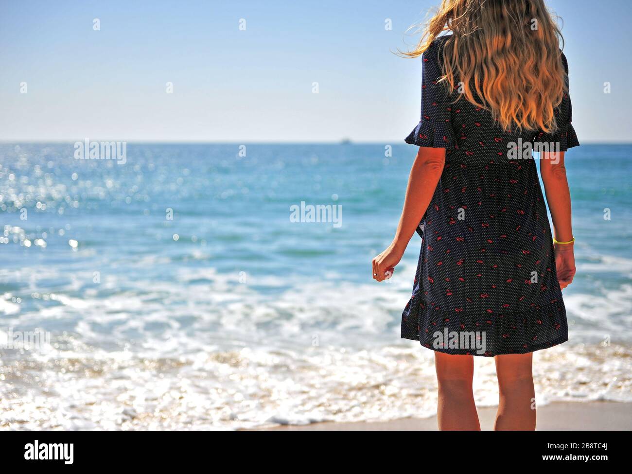 Rückblick auf junge Frau am Meer mit Blick auf Horizont Stockfoto