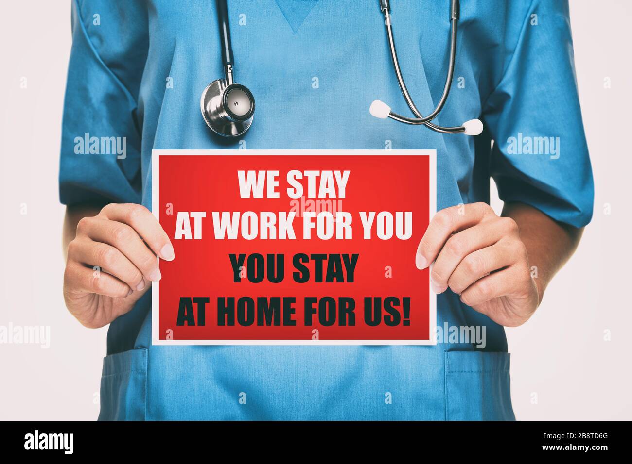 COVID-19 Coronavirus Arzt mit Schild für virale Social-Media-Post zeigen: Wir bleiben bei der Arbeit für Sie, bitte bleiben Sie zu Hause für uns! Auf Karte. Krankenschwester Stockfoto