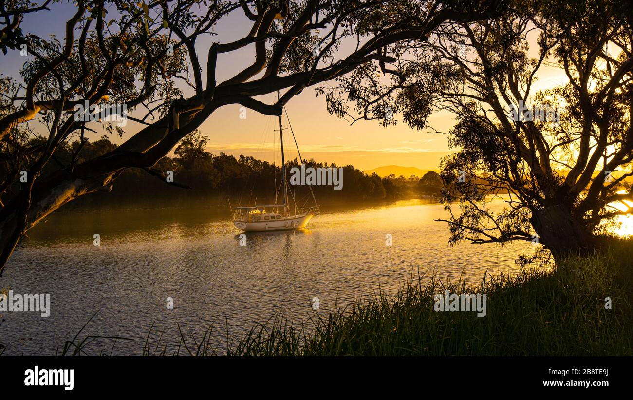 Eine Yacht, die am Moruya River, South Coast NSW, Australien, festgemacht wurde Stockfoto