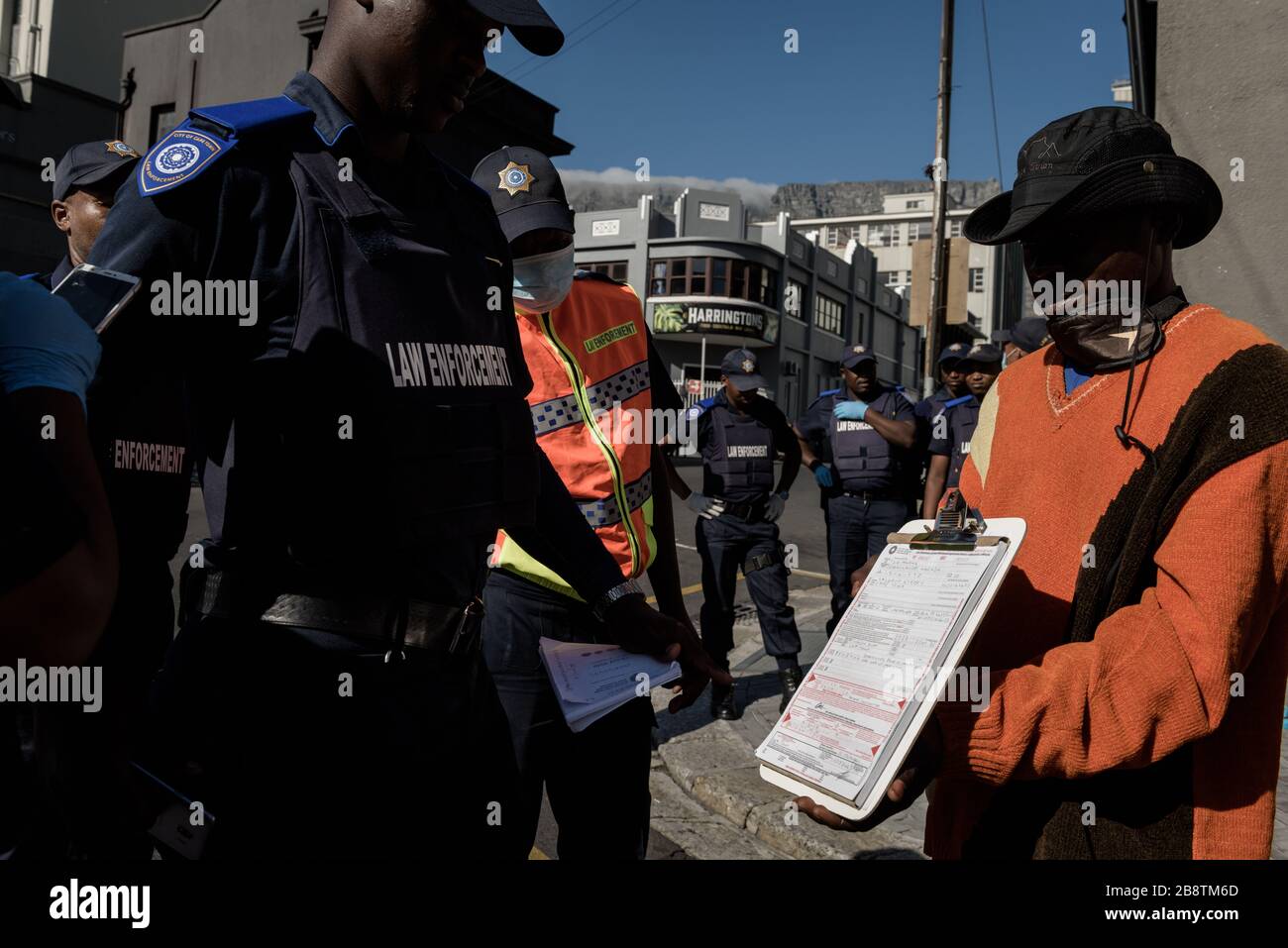 Die südafrikanische Polizei verhängt Geldstrafen gegen obdachlose ausländische Flüchtlinge aus Afrika wegen Verstoßes gegen die Gesetze auf Wiedersehen in Kapstadt während des Ausbruchs des Coronavirus Stockfoto