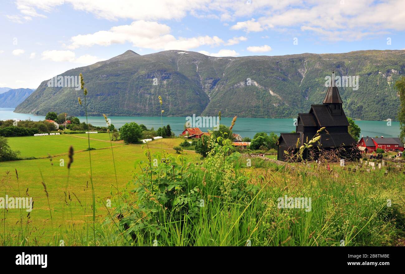 Panoramablick auf die alte Kirche mit See und Bergen im Hintergrund. Dorf Ornes, Norwegen Stockfoto