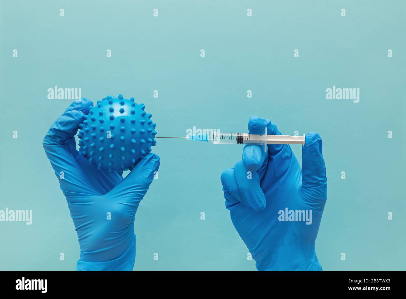 Hand in medizinischen Handschuh hält Spritze und abstrakte Virus-Modell Stockfoto