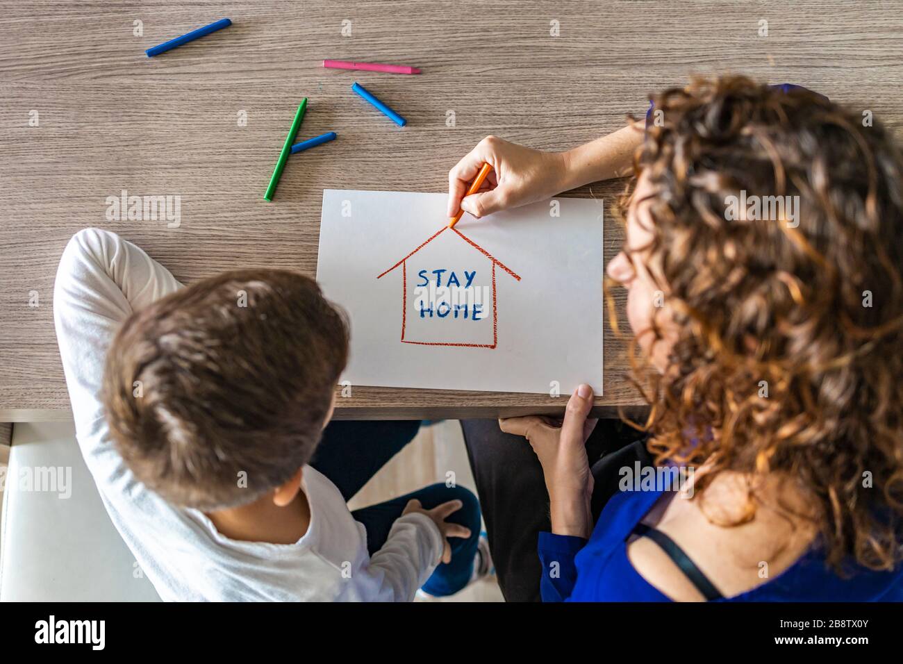Mutter und Sohn zeichnen "Stay Home"-Logo. Coronavirus Konzept Stockfoto