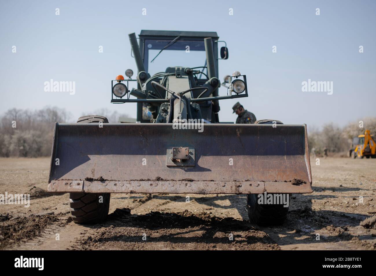 Details eines Armee-Traktors, der den Boden für ein mobiles Kampagnenkrankenhaus zur Behandlung von Covid-19-Patienten ebnen soll. Stockfoto