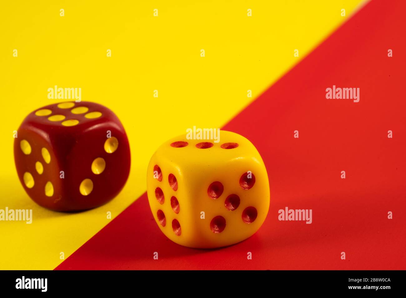 Glückswürfel. Zwei rote und gelbe Würfel auf rotem und gelbem Hintergrund, Kopierbereich, Glückssymbol Stockfoto