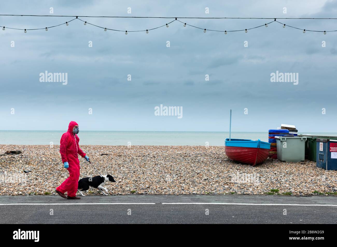 20/03/2020 - EIN Rentner, der nicht genannt werden wollte, läuft während der britischen Coronavirus Pandemie seinen Hund an der Küste von Worthing, West Sussex. Stockfoto