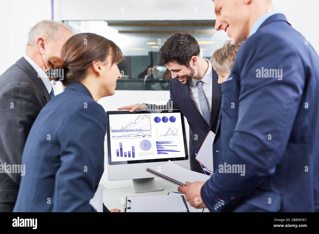 Eine Gruppe von Geschäftsleuten betrachtet Diagramme auf einem Monitor vom Computer aus Stockfoto