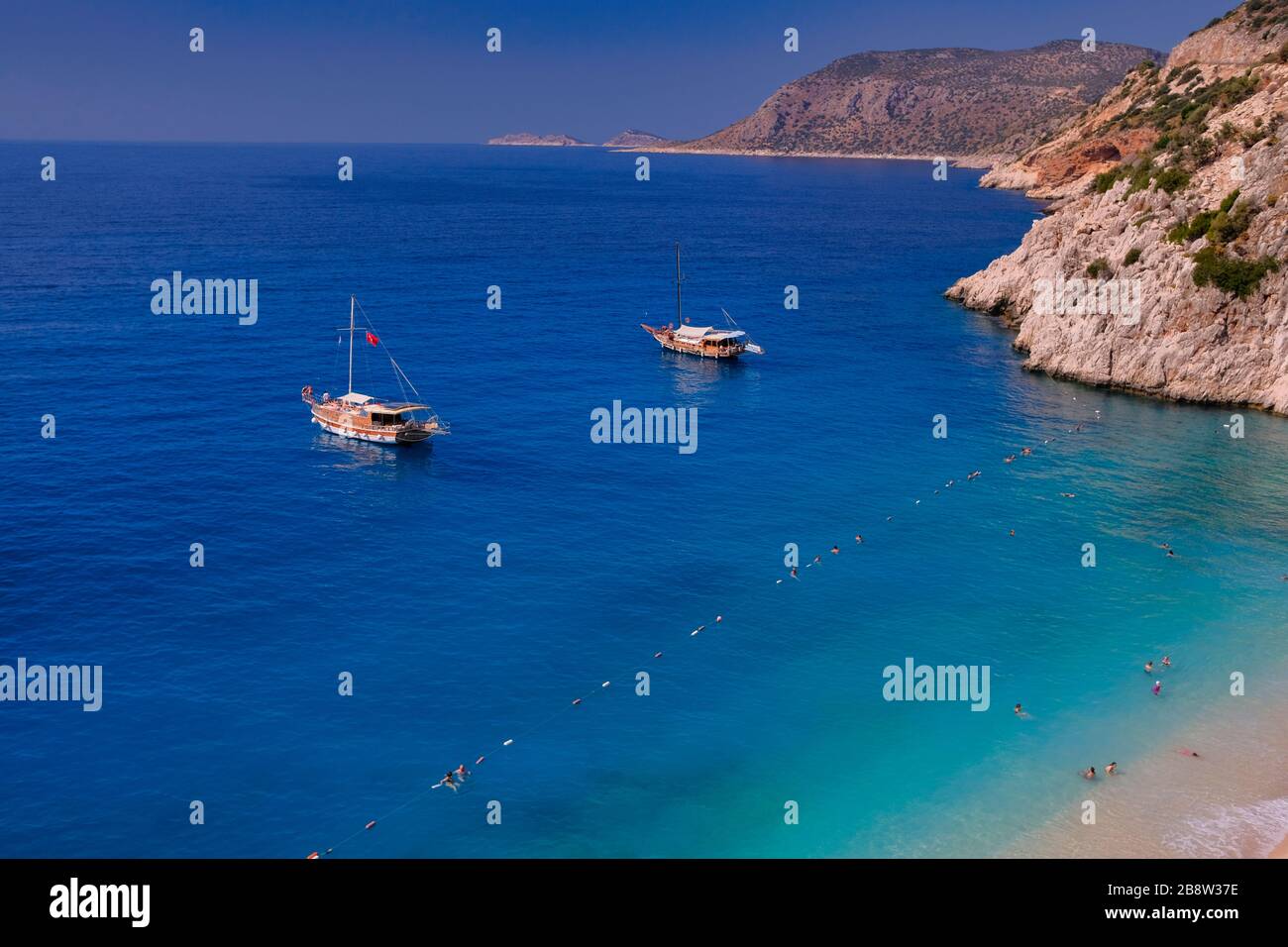 Paradiesischer Strand in Kas, Antalya - Türkei. Leerer Strand mit geschlossenen Sonnenschirmen am türkischen Strand Kaputaj Kemer Antalya. Stockfoto