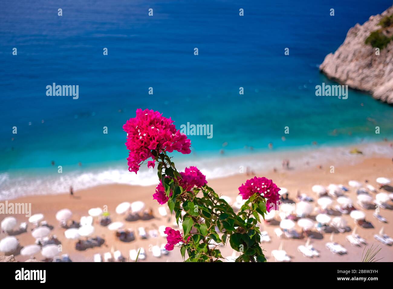 Paradiesischer Strand in Kas, Antalya - Türkei. Leerer Strand mit geschlossenen Sonnenschirmen am türkischen Strand Kaputaj Kemer Antalya. Stockfoto