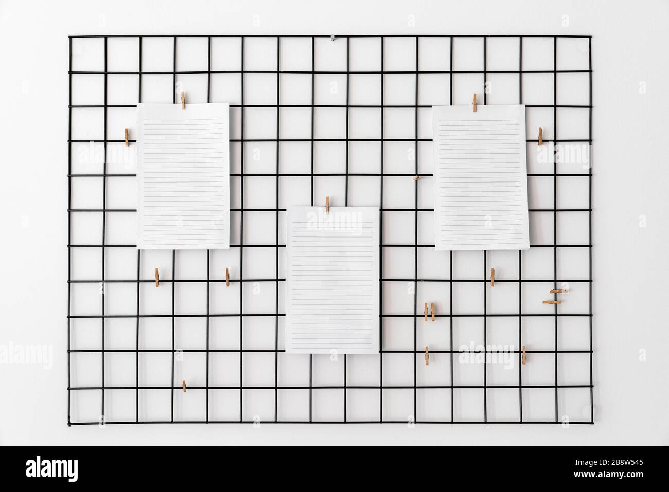 Leeres Papier, das mit Haken im Raster als Hinweis, Erinnerung oder Plantafel für die erfolgreiche Ausführung von Aufgaben oder Zielen angebracht ist Stockfoto