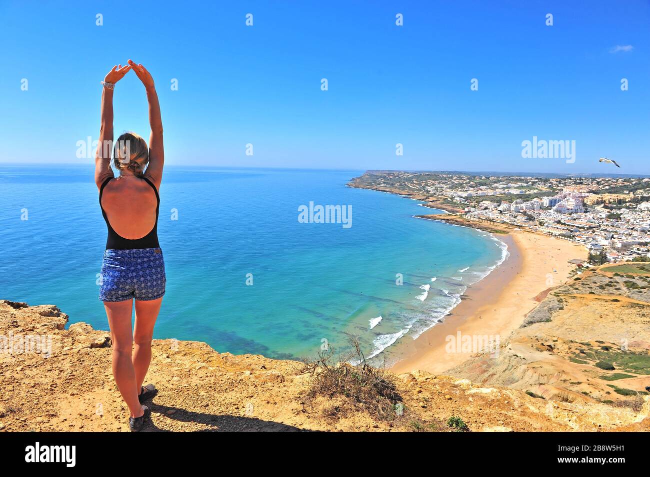 Junge Frau, die an der Spitze über dem Meer steht, Portugal Stockfoto
