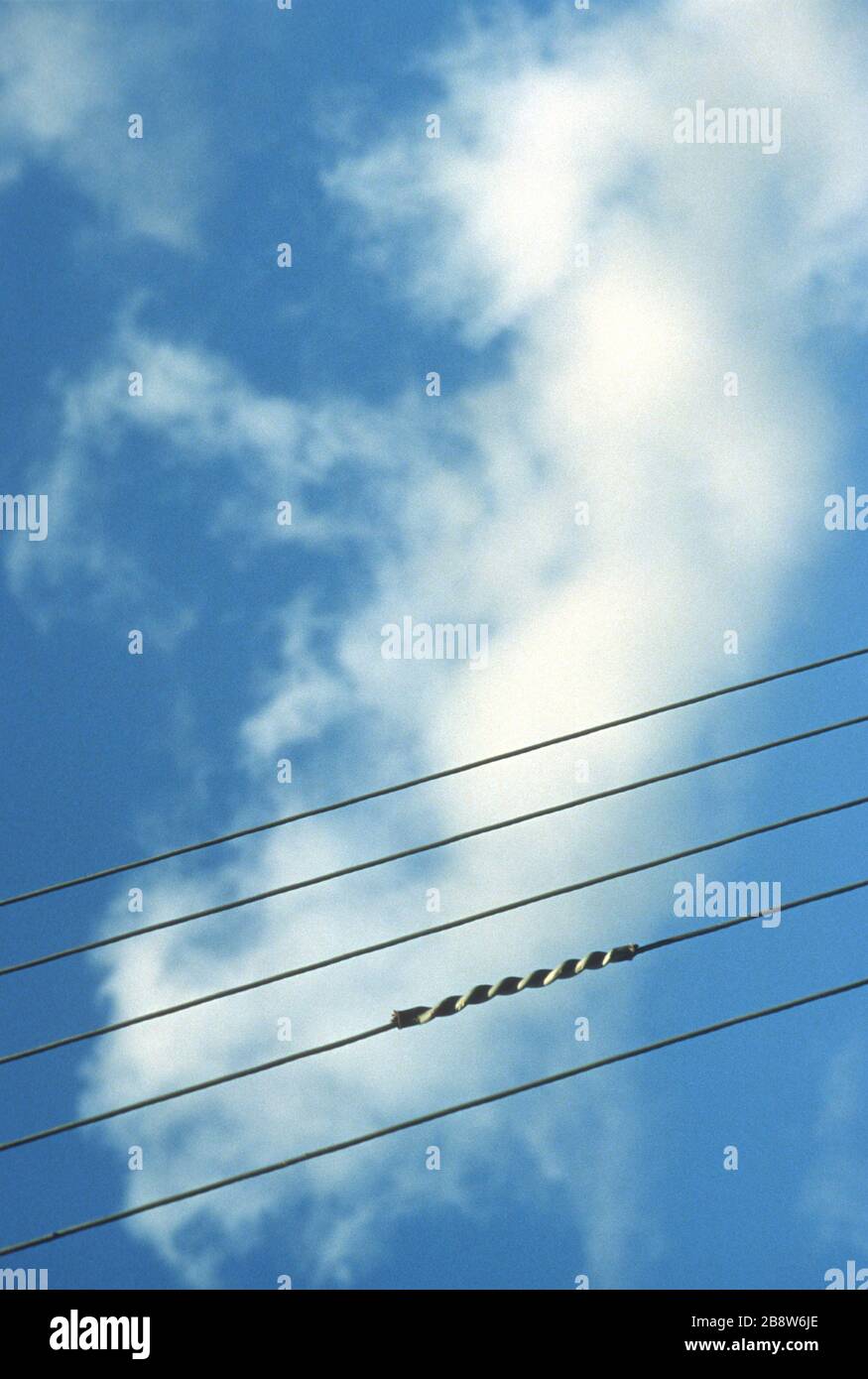 Fünf gegen einen blauen Himmel isolierte Telefon-/Strom-/Telegrafenleitungen sehen aus wie Musikstaven. Legen Sie Ihre eigenen Notizen in den Hintergrund. Stockfoto