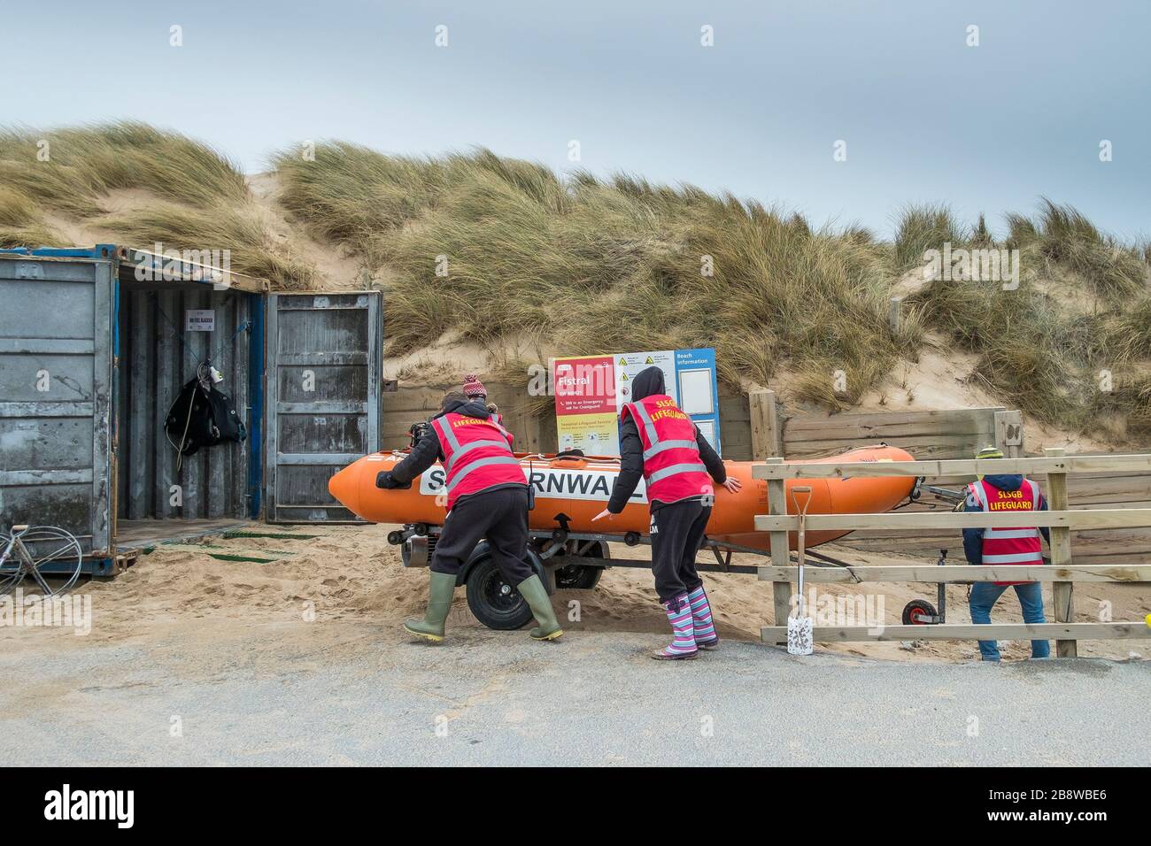 Mitglieder des Newquay Surf Lifesaving Club laden ihren lebensrettenden RIB in einen Vorratsbehälter bei Fistral in Newquay in Cornwall. Stockfoto