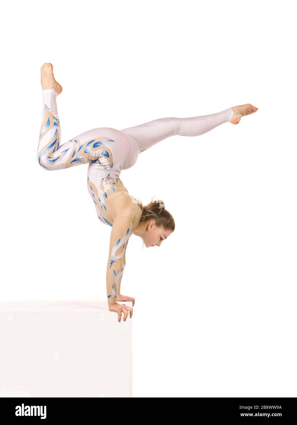 Akrobat Turnen, ein junger Zirkuskünstler in einem weißen und blauen Anzug, führt akrobatische Elemente aus. Studio, das ein isoliertes Bild auf weißem Hintergrund abschießt Stockfoto