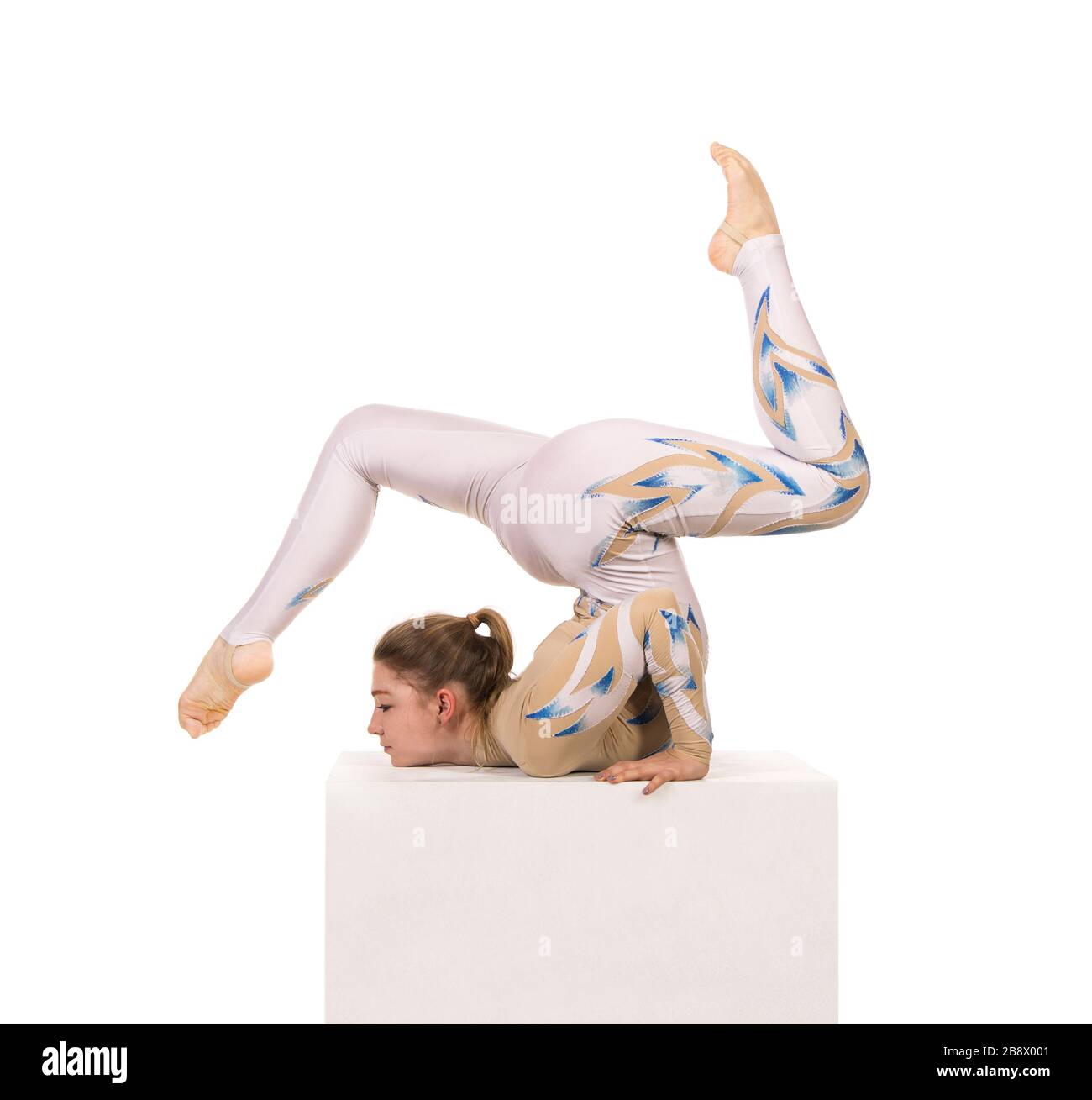Akrobat Turnen, ein junger Zirkuskünstler in einem weißen und blauen Anzug, führt akrobatische Elemente aus. Studio, das ein isoliertes Bild auf weißem Hintergrund abschießt Stockfoto