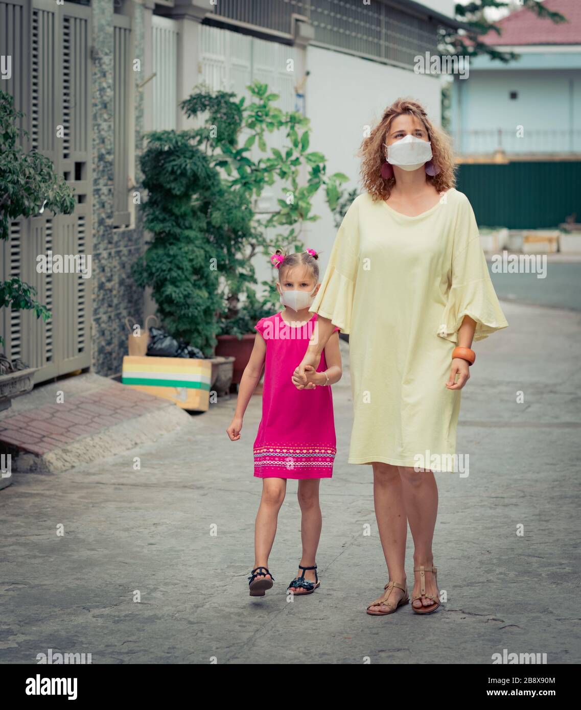 Frau und Tochter tragen eine Einwegmaske, um Virusinfektionen zu vermeiden. Schutz vor Coronavirus Stockfoto