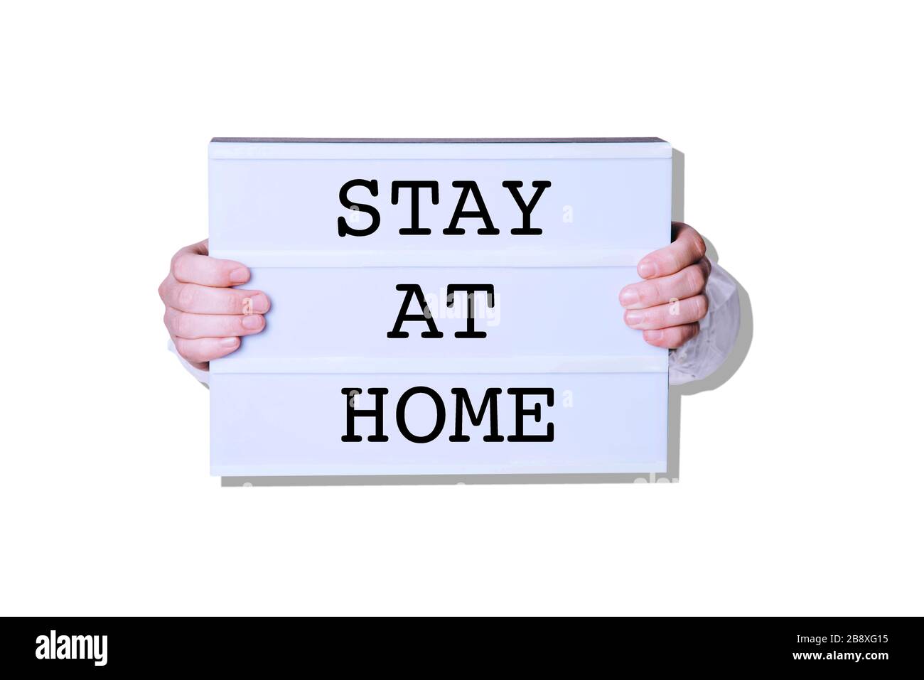 Männliche Hände mit "Stay at Home"-Schild auf weißem Hintergrund. Stockfoto