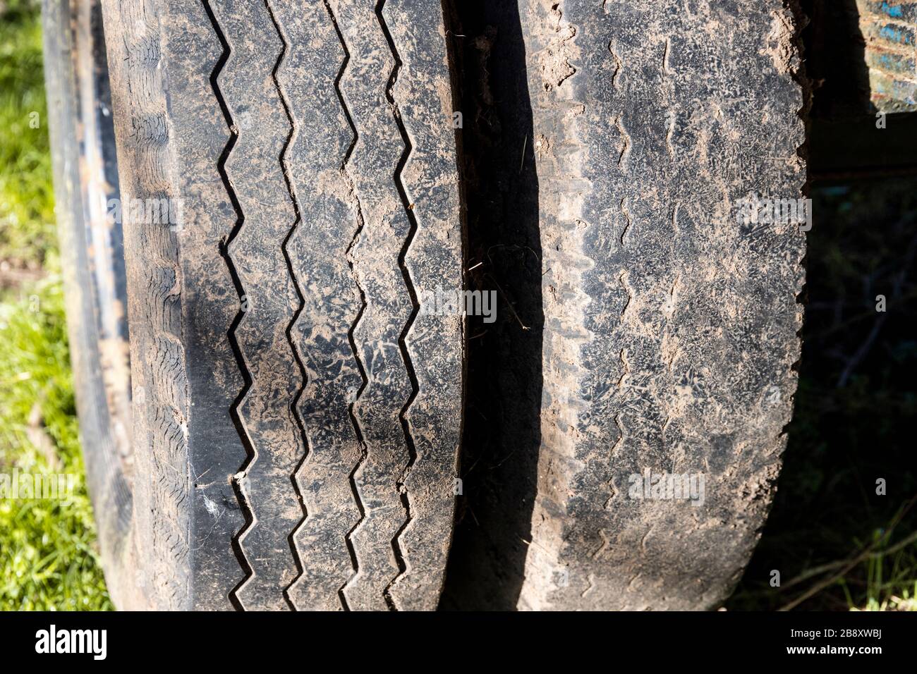 Eine Nahaufnahme eines legalen Reifens und eines illegalen Reifens auf einem Bauernauflieger in North Cerney, Gloucestershire UK Stockfoto