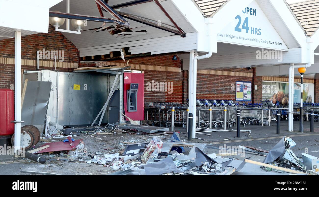 Die Szene im Tesco Extra Store in Whitfield, Dover, Kent, wo Diebe einen Ausgräber zur Durchführung eines rammüberfalls verwendet haben - einen Geldautomaten von der Wand reißend und zwei Polizeifahrzeuge beschädigt haben, während sie versuchten zu entkommen. Stockfoto