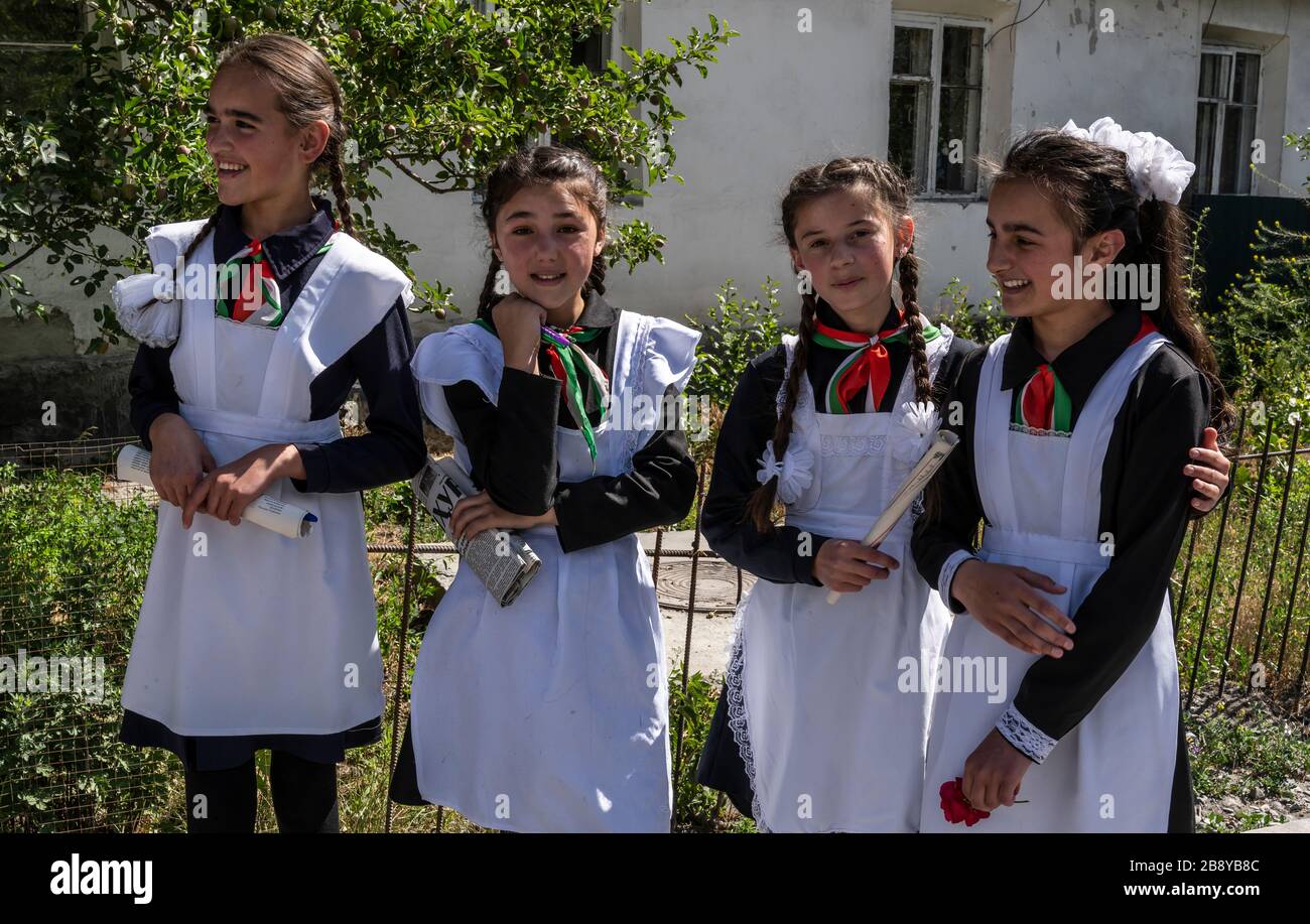 Rushon, Tadschikistan - 17. Juni 2020: Vier Schulkinder, Mädchen, in Schultracht vor der Schule am Pamir-Highway in Tadschikistan. Stockfoto