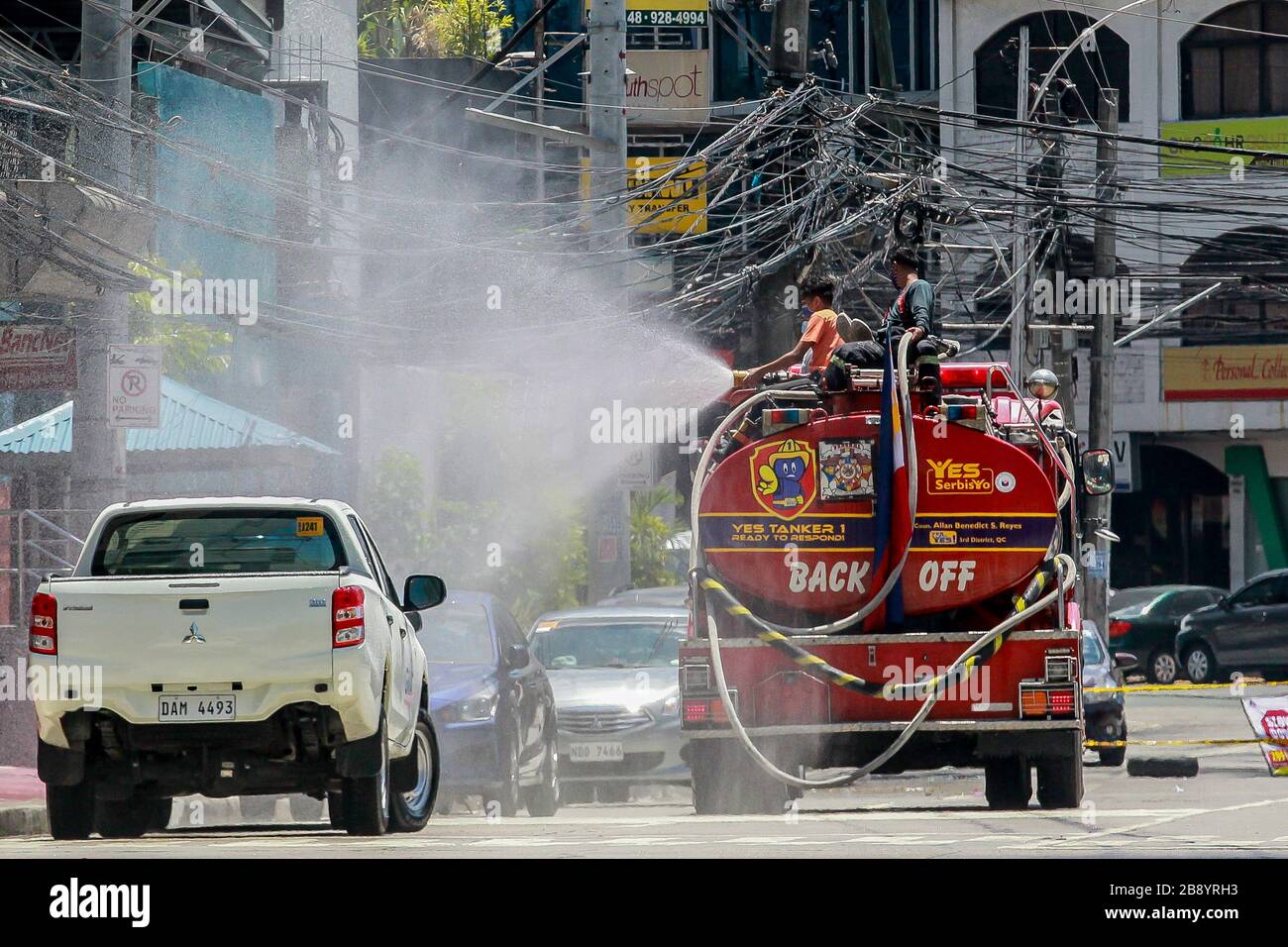 Quezon City, Philippinen. März 2020. Feuerwehrleute sprühen auf einer Straße in Quezon City, Philippinen, am 23. März 2020 Desinfektionsmittel auf einen Feuerwehrwagen. Die Zahl der COVID-19-Fälle auf den Philippinen ist auf 462 gestiegen, sagte das Gesundheitsministerium des Landes (DOH) am Montag. Der DOH sagte in einem Bericht, dass 33 Menschen an der hochinfektiösen Krankheit gestorben seien, während 18 sich erholt hätten. Credit: Rouelle Umali/Xinhua/Alamy Live News Stockfoto