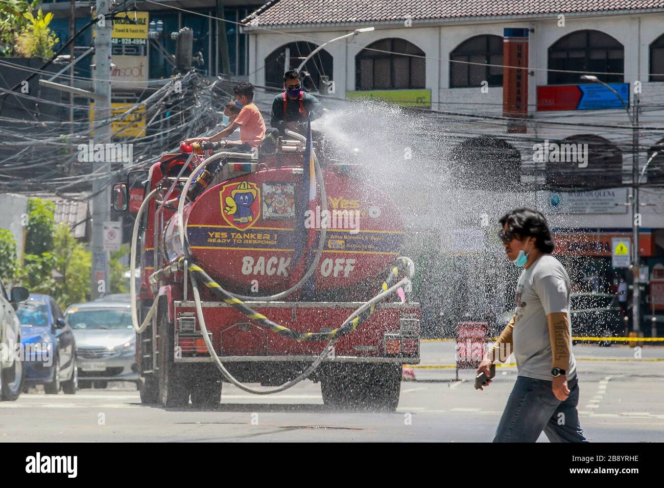 Quezon City, Philippinen. März 2020. Feuerwehrleute sprühen auf einer Straße in Quezon City, Philippinen, am 23. März 2020 Desinfektionsmittel auf einen Feuerwehrwagen. Die Zahl der COVID-19-Fälle auf den Philippinen ist auf 462 gestiegen, sagte das Gesundheitsministerium des Landes (DOH) am Montag. Der DOH sagte in einem Bericht, dass 33 Menschen an der hochinfektiösen Krankheit gestorben seien, während 18 sich erholt hätten. Credit: Rouelle Umali/Xinhua/Alamy Live News Stockfoto