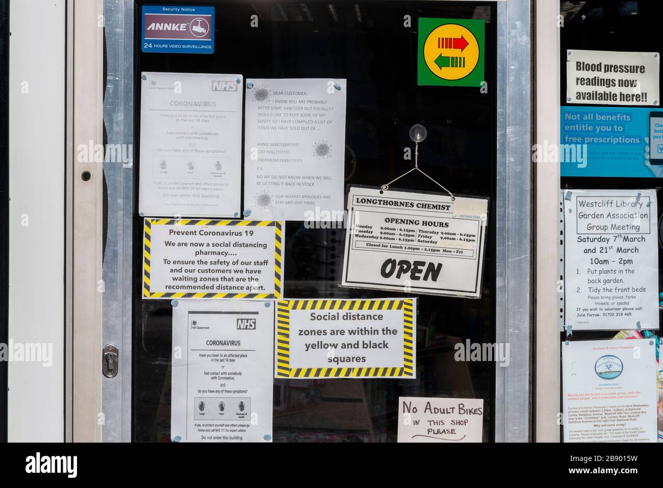 Mehrere Zeichen an der Fenstertür für einen Chemiker, die Warnungen zu einer COVID-19-Coronavirus-Pandemie anzeigen. Soziale Distanzierungszonen. NHS-Apotheke Stockfoto