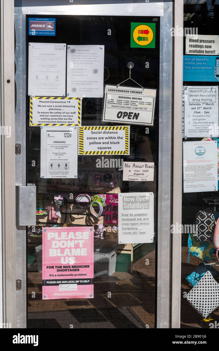Mehrere Zeichen an der Fenstertür für einen Chemiker, die Warnungen zu einer COVID-19-Coronavirus-Pandemie anzeigen. Soziale Distanzierungszonen. NHS-Apotheke Stockfoto