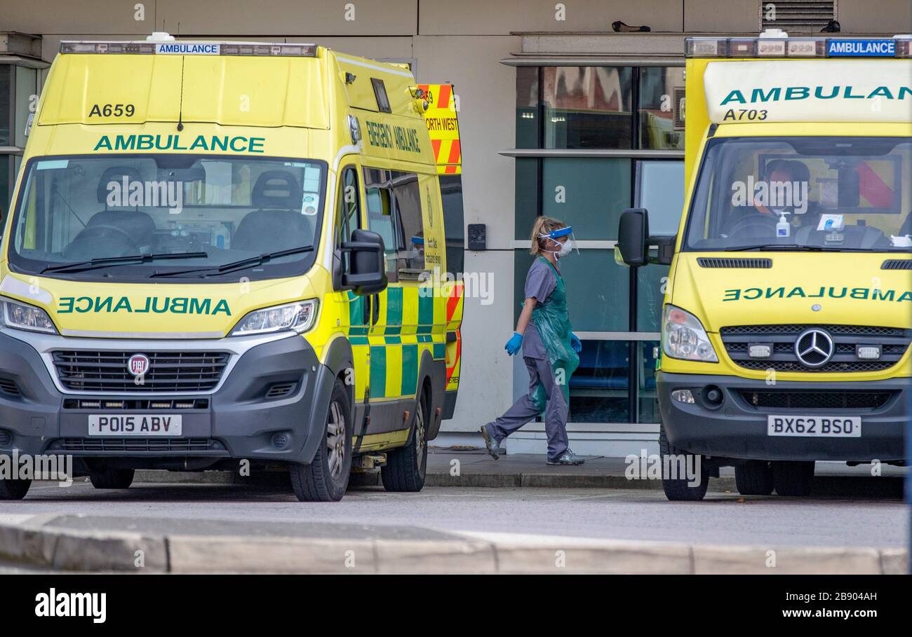 Krankenhausmitarbeiter und Krankenwagenmitarbeiter bereiten sich darauf vor, einen Patienten in das Royal Liverpool University Hospital zu bringen, da Premierminister Boris Johnson sagte, die Regierung sei bereit, härtere Beschränkungen zu verhängen, um die Ausbreitung des Coronavirus einzudämmen, wenn die Menschen nicht den Leitlinien zur sozialen Distanzierung folgen. Stockfoto