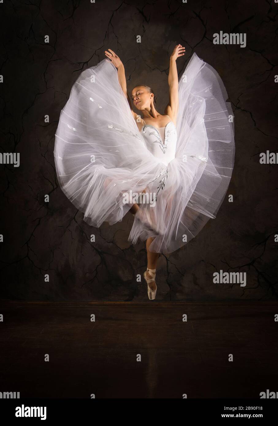 Schlanke Frau in einem weißen Korsett tutu tanzen Ballett. Studio-Aufnahmen vor dunklem Hintergrund, isolierte Bilder. Stockfoto