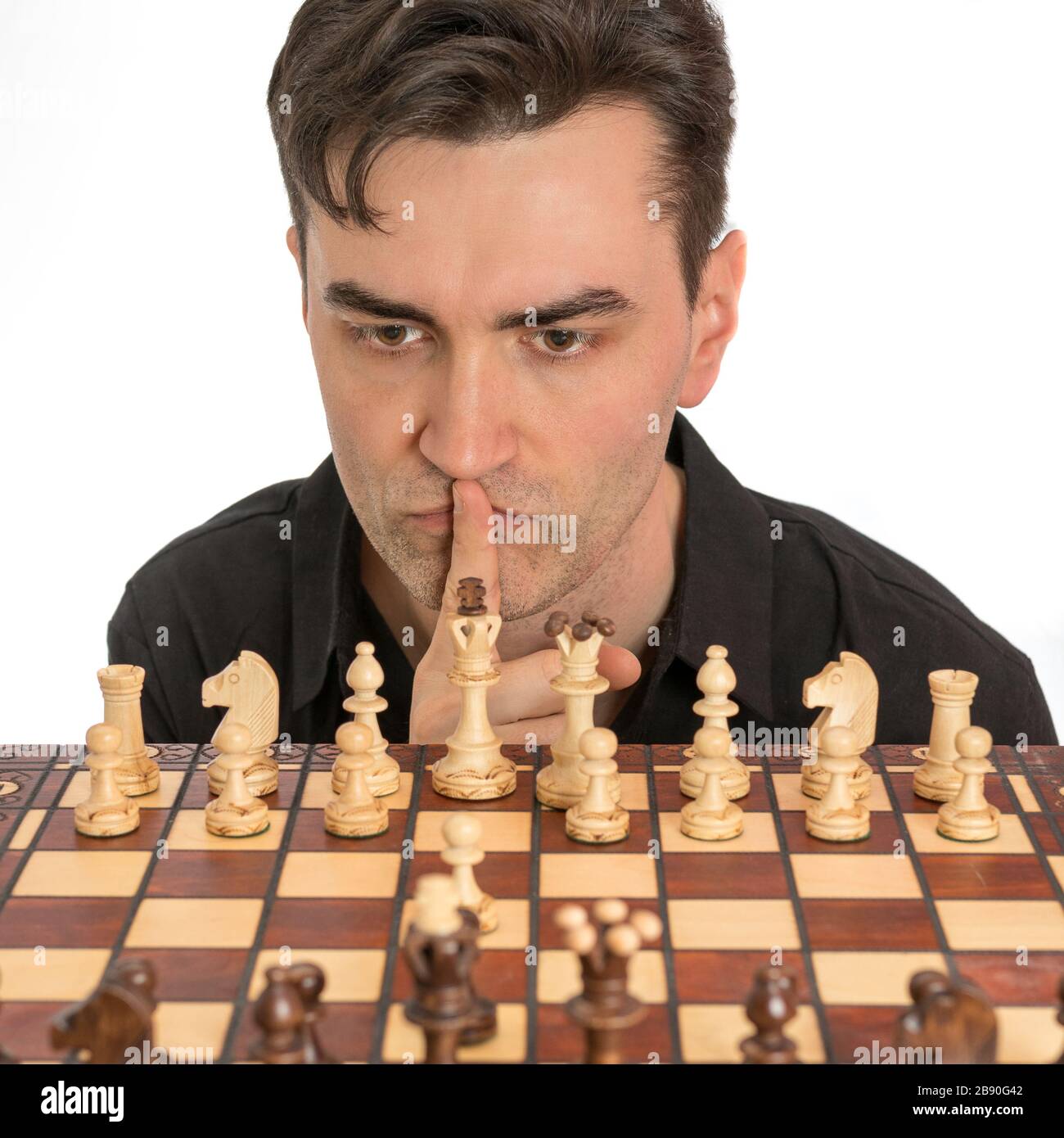 Kaukasischer Mann denkt über seinen zweiten Schachzug nach. Lizenzfreies Foto. Stockfoto