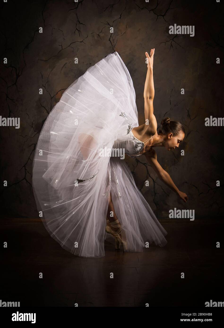 Schlanke Frau in einem weißen Korsett tutu tanzen Ballett. Studio-Aufnahmen vor dunklem Hintergrund, isolierte Bilder. Stockfoto