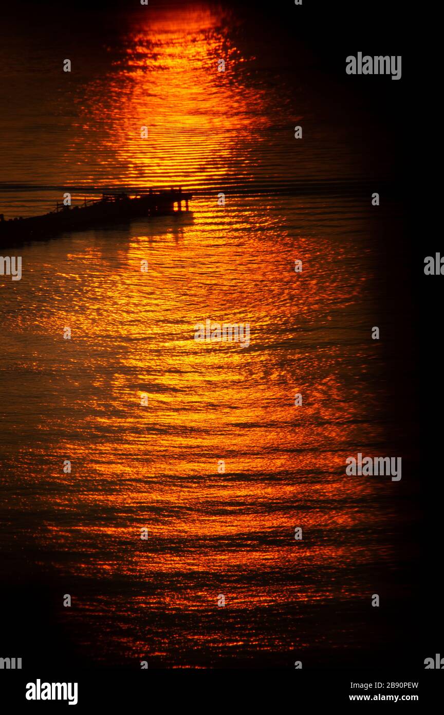 Golden-hour-Licht über einsamem Pier Stockfoto