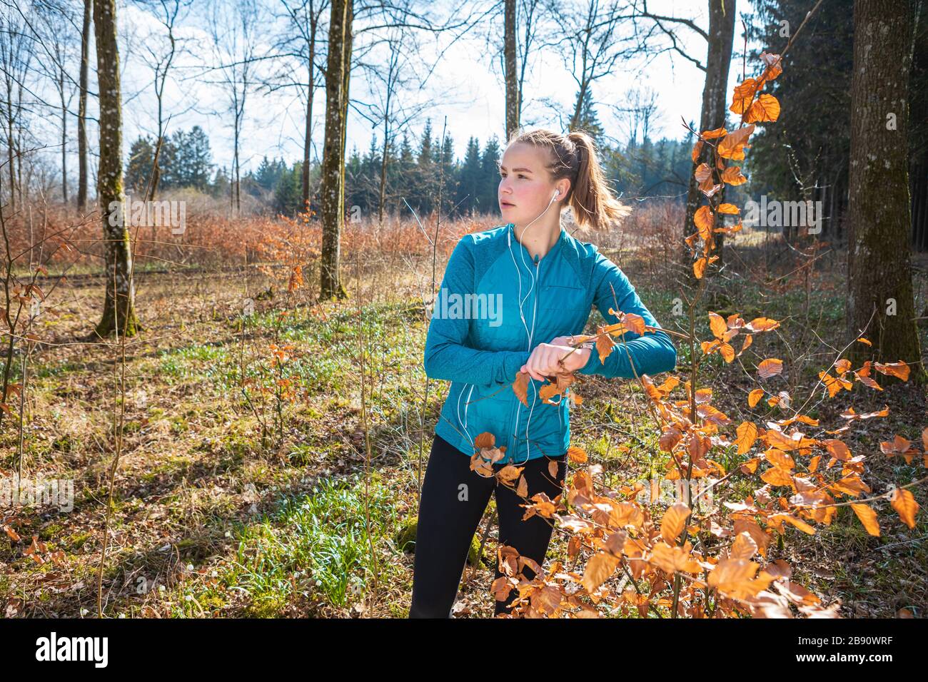 Junges Mädchen, das im Frühling im Wald joggt Stockfoto