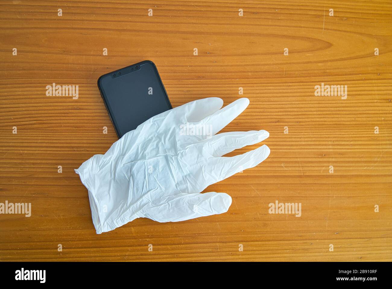 Guantes de látex blancos para proteger el uso del teléfono inteligente contra el Covid-19. Coronavirus, Virus y enfermedades contagiosas. Protéjase cu Stockfoto